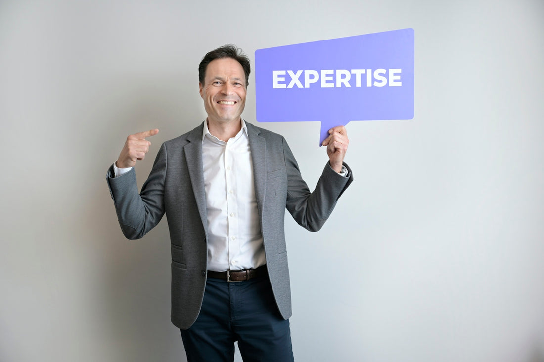 A man points to himself holding an expertise sign